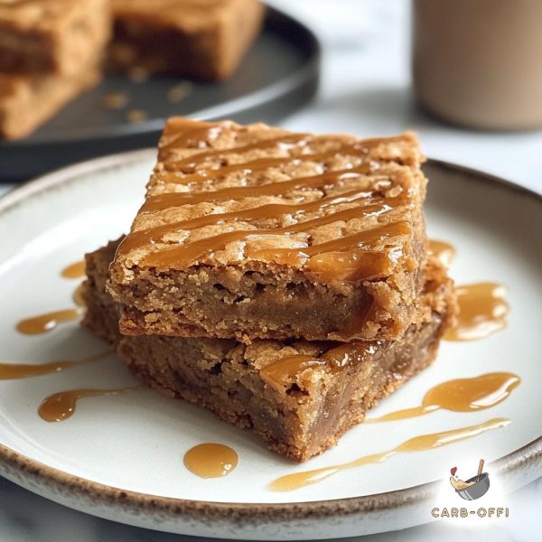 Two large, square pieces of salted caramel blondies on a round, white plate