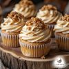 Five vanilla cupcakes with off-brown colour frosting topped with pieces of smashed caramel on a wooden board